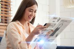 Mulher feliz usando celular e olhando catálogo de produtos de moda e acessórios de joias, promovendo compras online de itens de moda com entusiasmo.